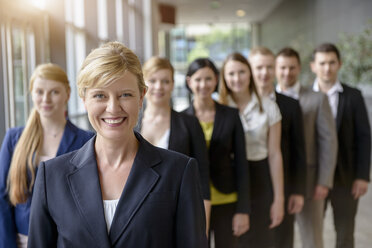 Portrait of businesswoman and business team standing in a row - ISF16580