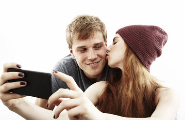 Studio-Porträt eines jungen Paares, das ein Selfie mit seinem Smartphone macht - ISF16582