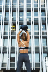 Sportive young woman with boxing gloves in the city raising her arms - KKAF01169