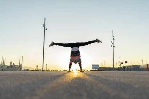 Akrobat beim Handstand in der Stadt bei Sonnenaufgang - AFVF00665