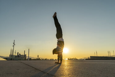 Akrobat beim Handstand in der Stadt bei Sonnenaufgang - AFVF00668