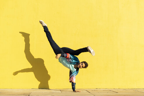 Acrobat doing movement training in front of a yellow wall - AFVF00698