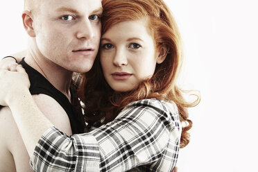 Studio-Porträt eines rothaarigen jungen Paares, das sich Wange an Wange umarmt - ISF16652