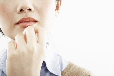 Cropped close up of hand on young woman's chin - ISF16657