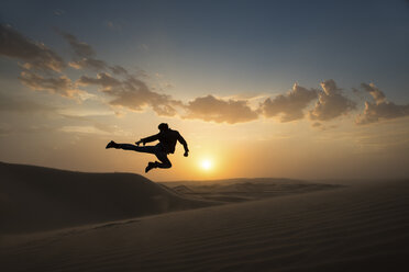 Man jumping mid air, Glamis sand dunes, California, USA - ISF16682