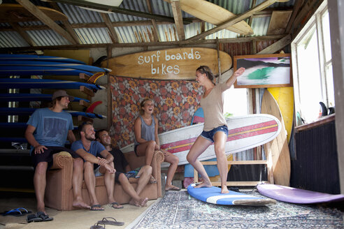 Fünf junge erwachsene Surferfreunde, die im Surfschuppen herumalbern - ISF16804