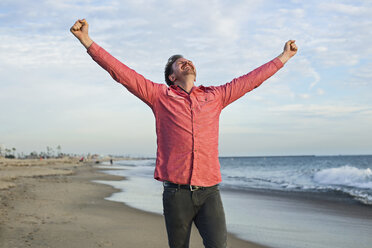 Young man celebrating on beach, Long Beach, California, USA - ISF16829