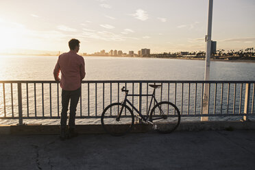 Young man gazing from pier, Long Beach, California, USA - ISF16830