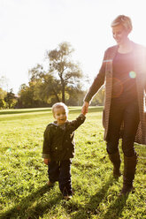 Mutter und Sohn gehen im Park spazieren - CUF39622