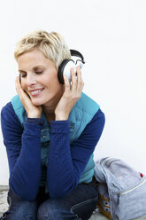 Smiling woman listening to headphones - CUF39668