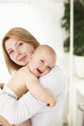 Lächelnde Mutter hält ihr kleines Mädchen - CUF39747