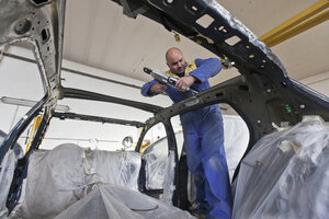 Mechaniker arbeitet an einem Auto in der Garage - CUF39751