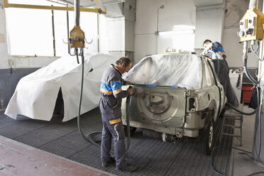 Mechaniker arbeiten an einem Auto in der Werkstatt - CUF39753