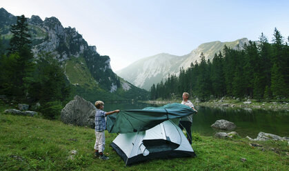 Vater und Sohn schlagen gemeinsam ihr Zelt auf - CUF39769
