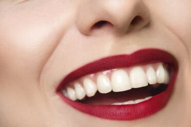 Cropped studio portrait of young woman's smiling mouth - CUF39803