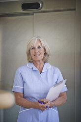 Porträt einer reifen Krankenschwester im Krankenhauskorridor - CUF39851