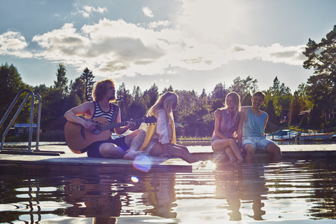 Zwei junge Paare entspannen sich am Pier, Gavle, Schweden, lizenzfreies Stockfoto