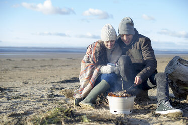 Junges Paar beim Grillen am Strand, Brean Sands, Somerset, England - CUF39883