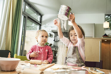 Girl sieving flour in kitchen - CUF39916