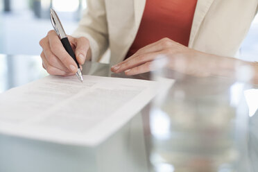 Cropped image of businesswoman signing paperwork - CUF39934