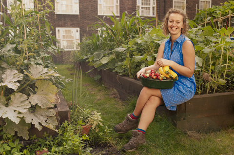 Young woman with harvested vegetables on council estate allotment stock photo