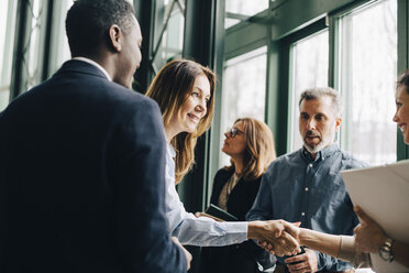 Mature businesswoman greeting colleagues in meeting at office - MASF08056