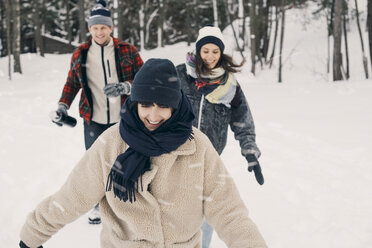Cheerful friends walking on snow covered field - MASF08131