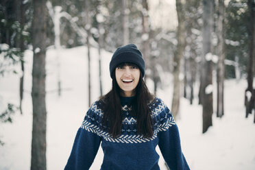 Portrait of smiling woman standing on snowy field during winter - MASF08142