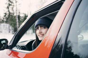 Porträt einer lächelnden Frau, die in einem roten Auto sitzt - MASF08162