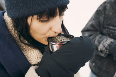 High angle view of woman drinking coffee while standing with friend - MASF08167