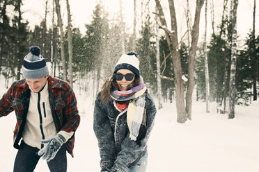 Happy friends playing on snow covered landscape - MASF08175