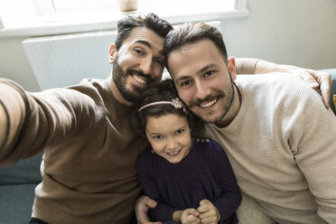 Lächelnde Väter und Tochter nehmen Selfie beim Sitzen auf dem Sofa im Wohnzimmer zu Hause - MASF08215