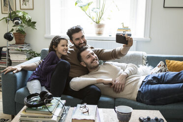 Väter nehmen Selfie mit Tochter durch Handy auf Sofa zu Hause - MASF08219