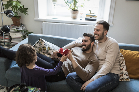 Hohe Winkel Ansicht der Tochter zeigt Blöcke zu lächelnden Vätern im Wohnzimmer, lizenzfreies Stockfoto