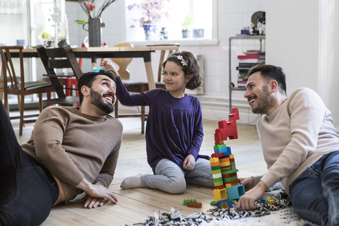 Fröhliche Tochter spielt mit Vätern zu Hause, lizenzfreies Stockfoto