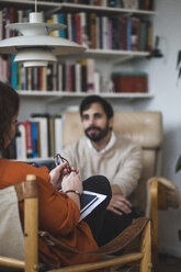 Weiblicher Therapeut mit männlichem Patienten während einer Therapiesitzung im Büro zu Hause - MASF08247