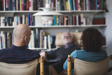 Älteres Paar diskutiert mit Therapeutin, während es am Bücherregal sitzt - MASF08249