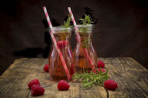 Zwei Glasflaschen mit hausgemachter Himbeerlimonade, aromatisiert mit Rosmarin - LVF07235