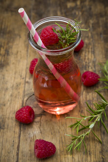 Glass bottle of homemade raspberry lemonade flavoured with rosemary - LVF07239
