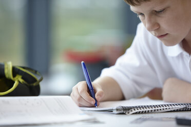 Close up of schoolboy writing in class - CUF40074