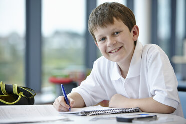 Portrait of schoolboy writing in class - CUF40075