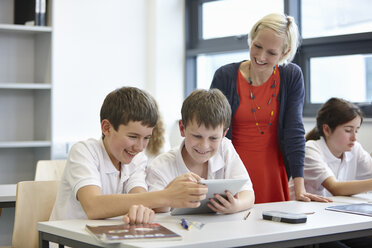 Schüler bei der Arbeit im Unterricht mit dem Lehrer - CUF40078