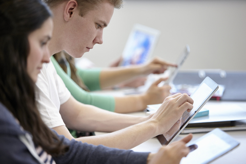 Teenager nutzen digitale Tablets im Klassenzimmer, lizenzfreies Stockfoto