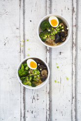 Two bowls of Ramen soup with egg, broccoli, noodles, shitake mushroom and spring onions - LVF07241