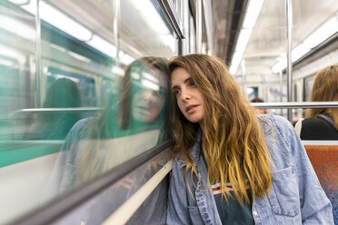 Porträt einer nachdenklichen jungen Frau in einem U-Bahn-Zug - AFVF00744