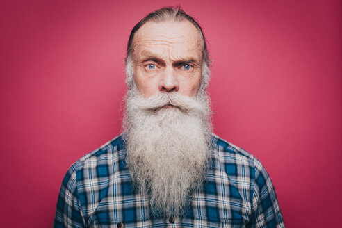 Porträt eines selbstbewussten älteren Mannes mit langem weißen Bart auf rosa Hintergrund - MASF08321