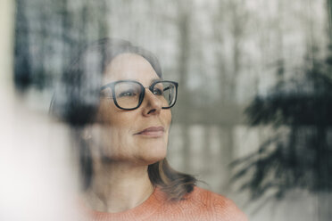 Close-up of thoughtful businesswoman wearing eyeglasses seen through window - MASF08345