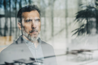 Close-up of thoughtful businessman seen through glass window at office - MASF08347