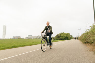 Voller Länge der älteren männlichen Pendler Radfahren auf der Straße gegen klaren Himmel - MASF08520