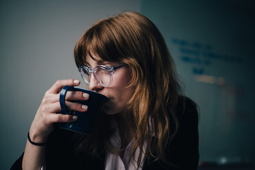 Young businesswoman drinking coffee at creative office - MASF08590